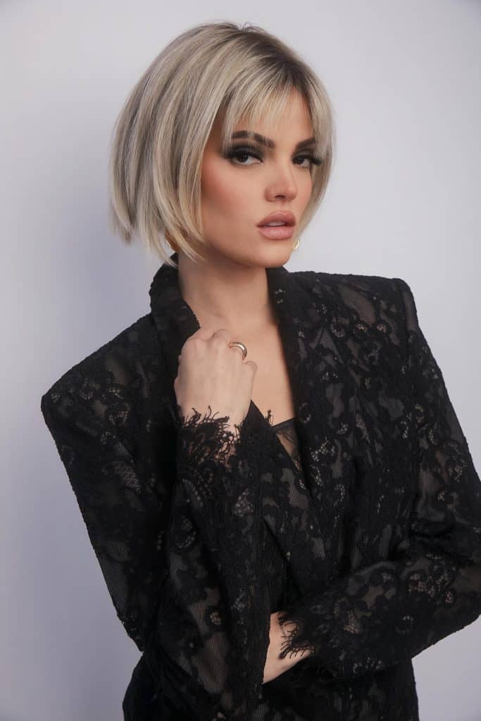 Blonde bob wig with layered cut and side-swept bangs from Hidden Secrets Wigs.